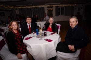 Four smiling adults sat around a circular table at our Valentine Dinner & Dance.