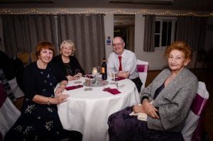 Four adults sat around a circular table at our Learn To Dance Valentine Dinner & Dance.