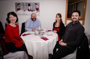 Four smiling adults sat around a circular table at our Valentine Dinner & Dance.